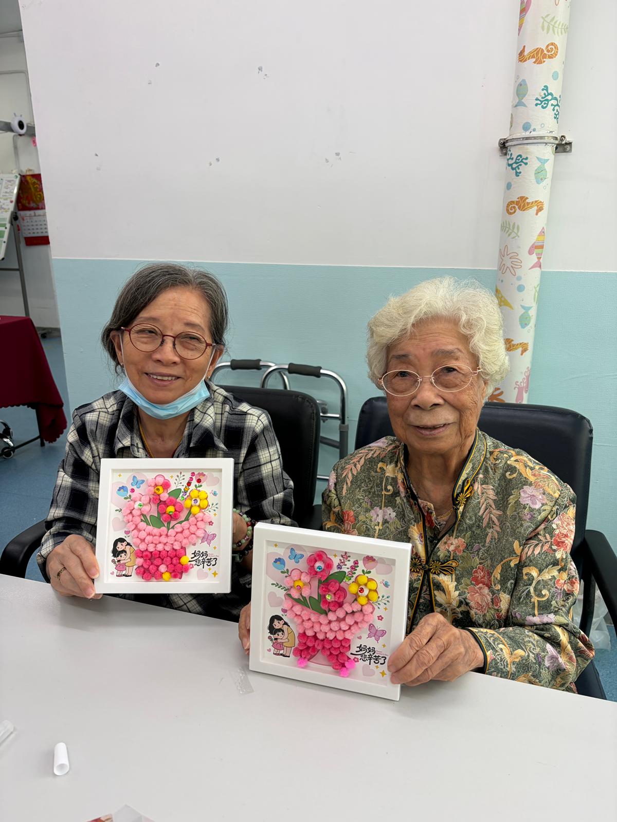兩位長者展示手作花藝作品